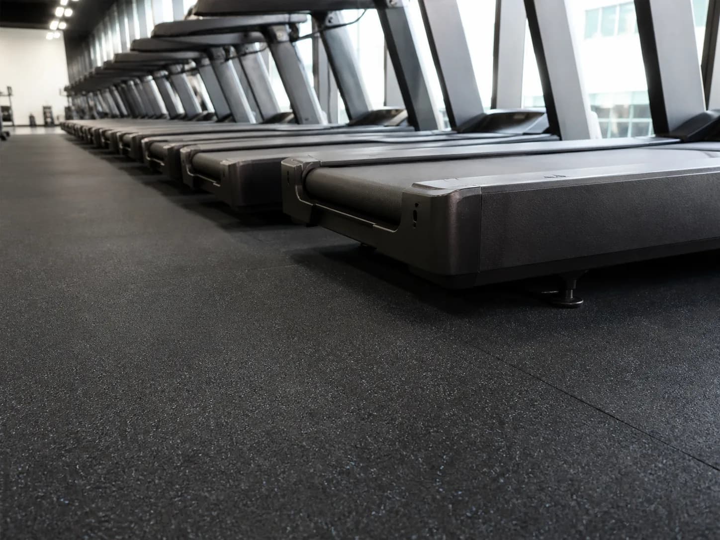 Treadmill feet resting on tight-seamed rubber roll flooring