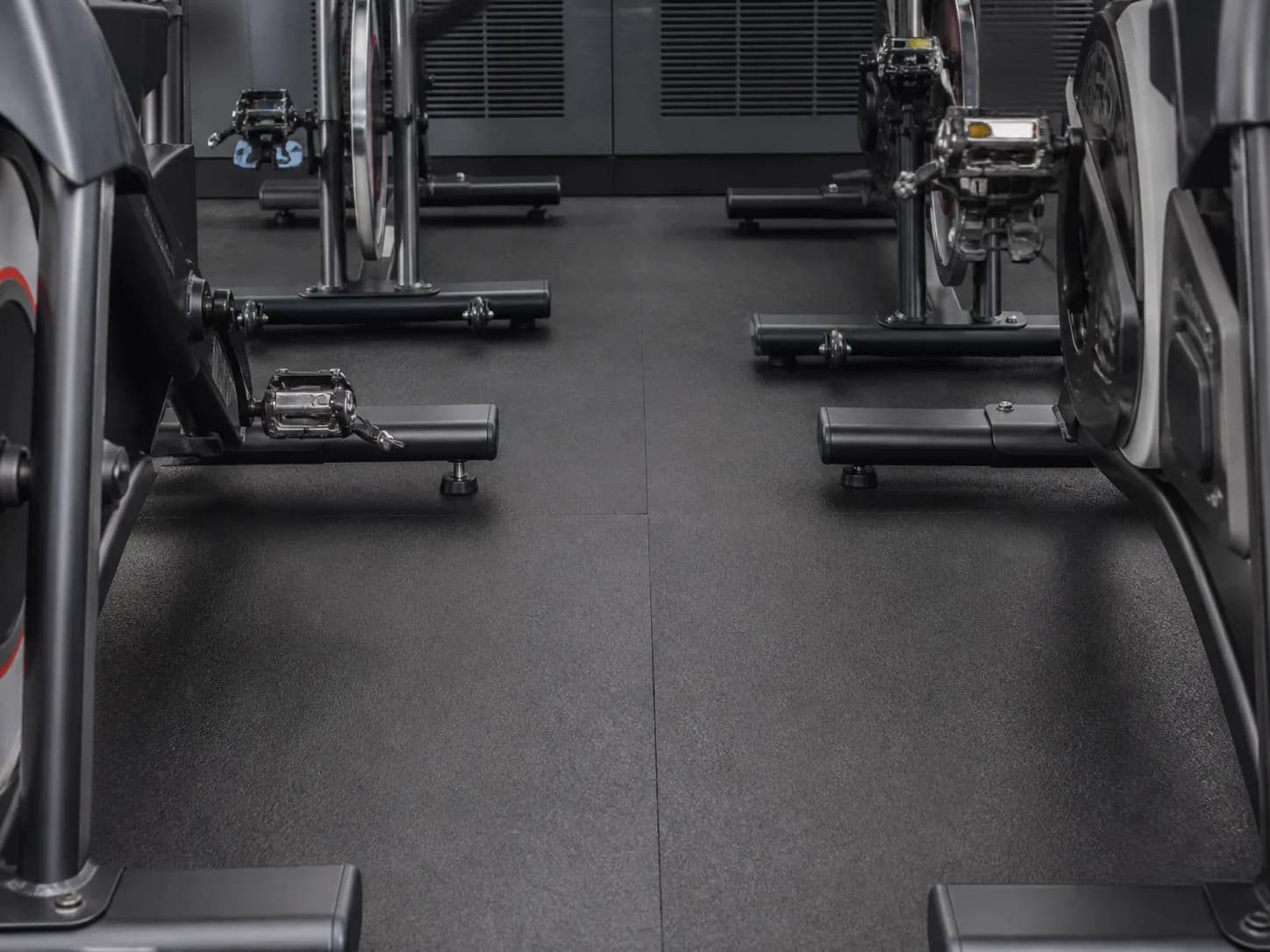 Stationary bike feet on tight-seamed easy-clean studio flooring
