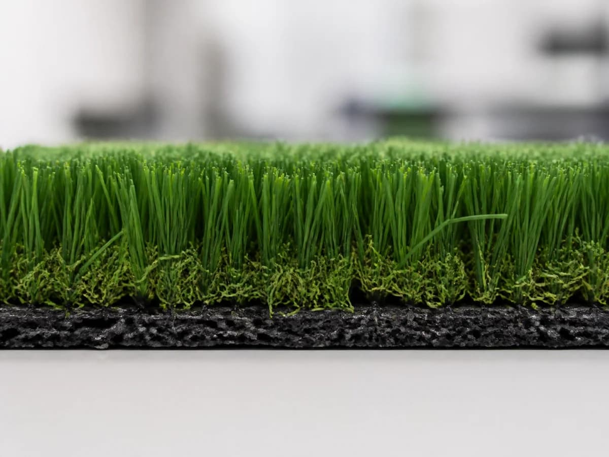 Macro product view showing synthetic gym turf pile and backing structure