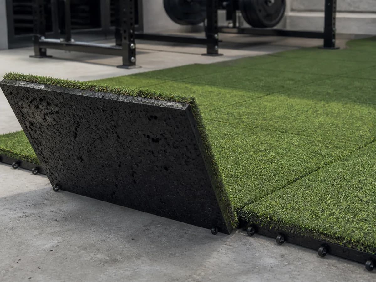 Hybrid turf tile lifted to show artificial grass face and rubber base