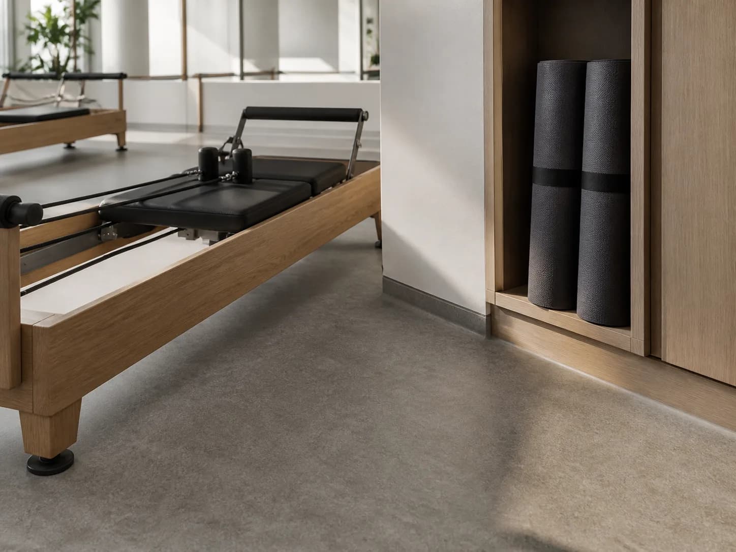 Pilates reformer feet on low-gloss easy-clean studio flooring