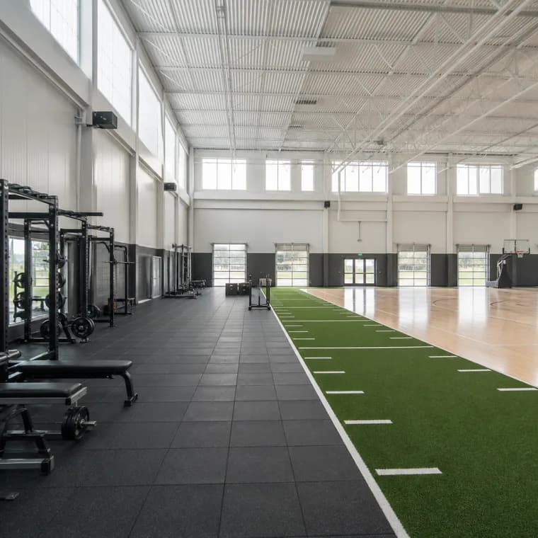 Indoor sports performance facility with rubber and turf zones