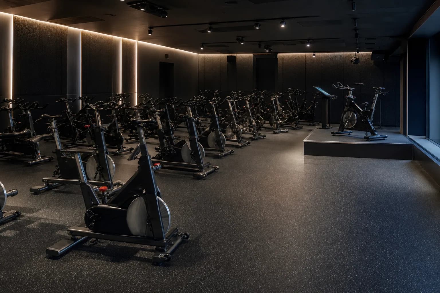 Indoor cycling studio: completed facility and full flooring concept using dense bonded rubber roll with platform and threshold details