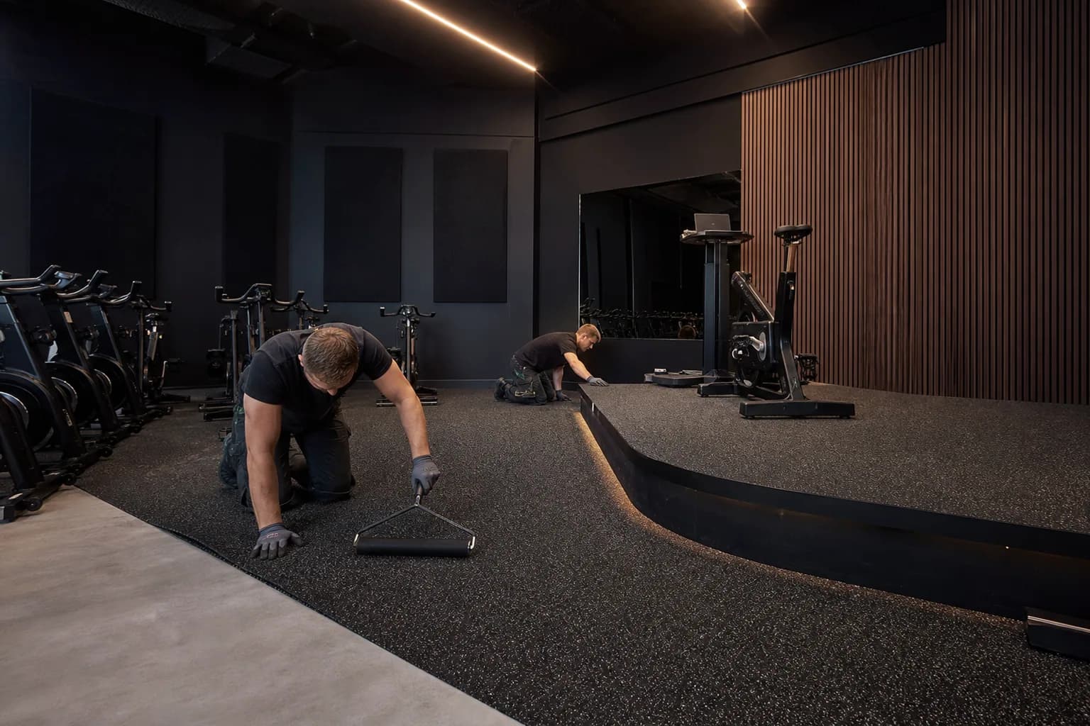 Indoor cycling studio: subfloor, set-out and installation control using dense bonded rubber roll with platform and threshold details