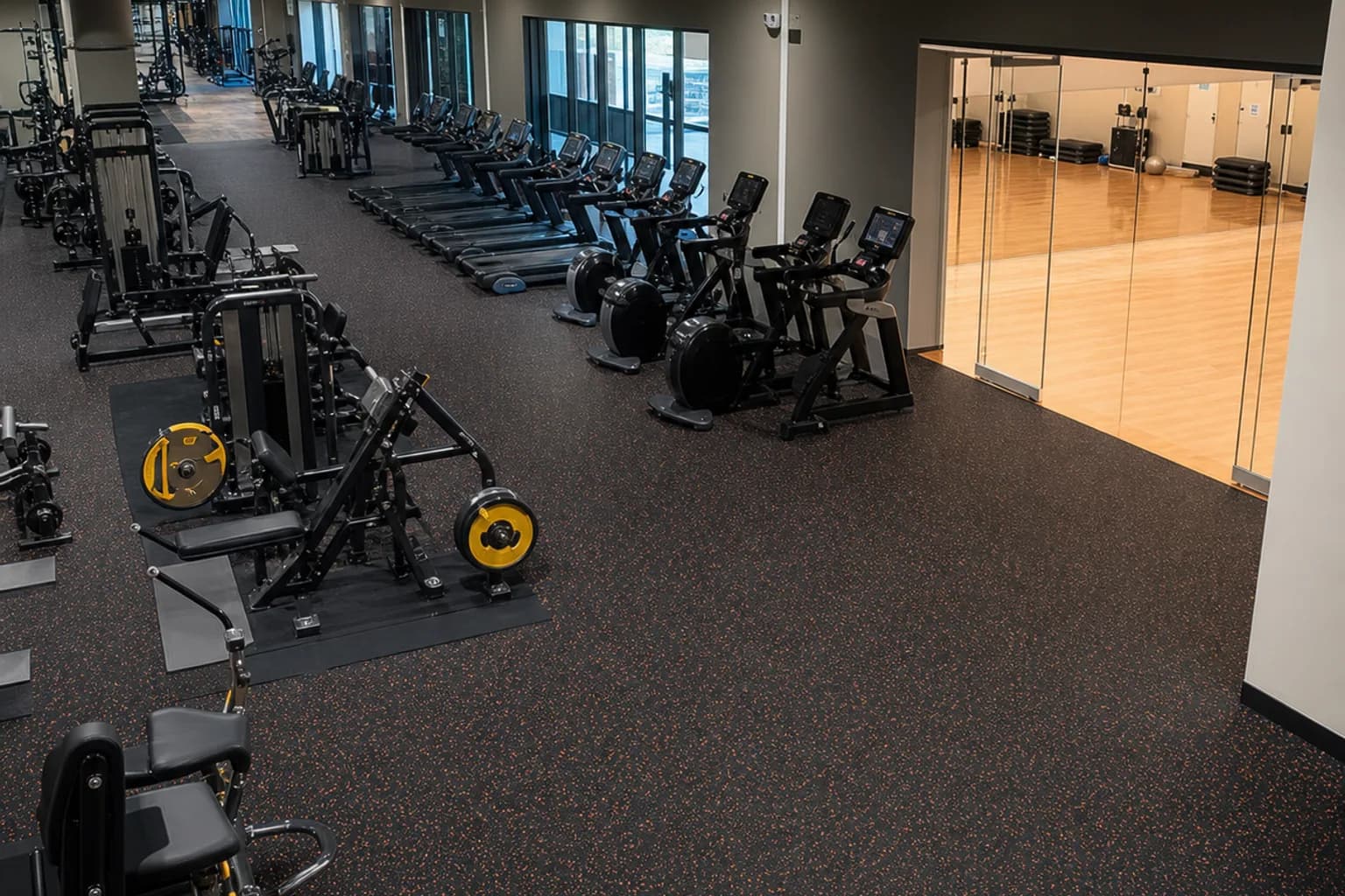 Large cardio and group-fitness center: completed facility and full flooring concept using bonded commercial rubber rolls with heavier local impact inserts