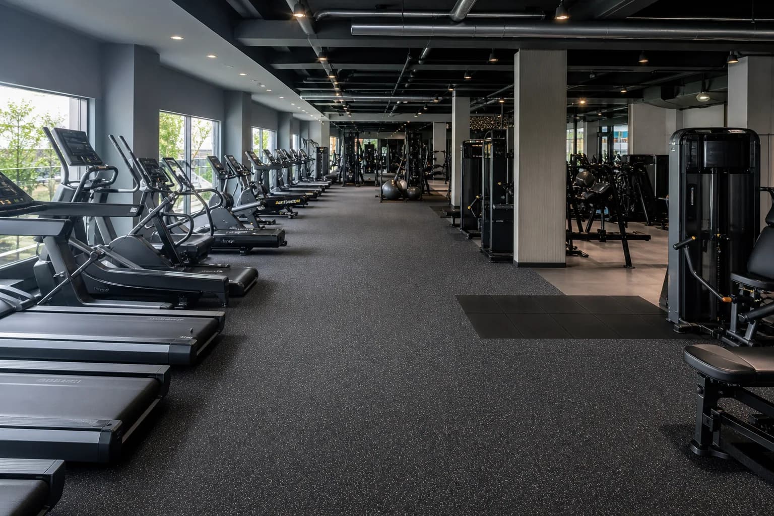 Large cardio and group-fitness center: subfloor, set-out and installation control using bonded commercial rubber rolls with heavier local impact inserts