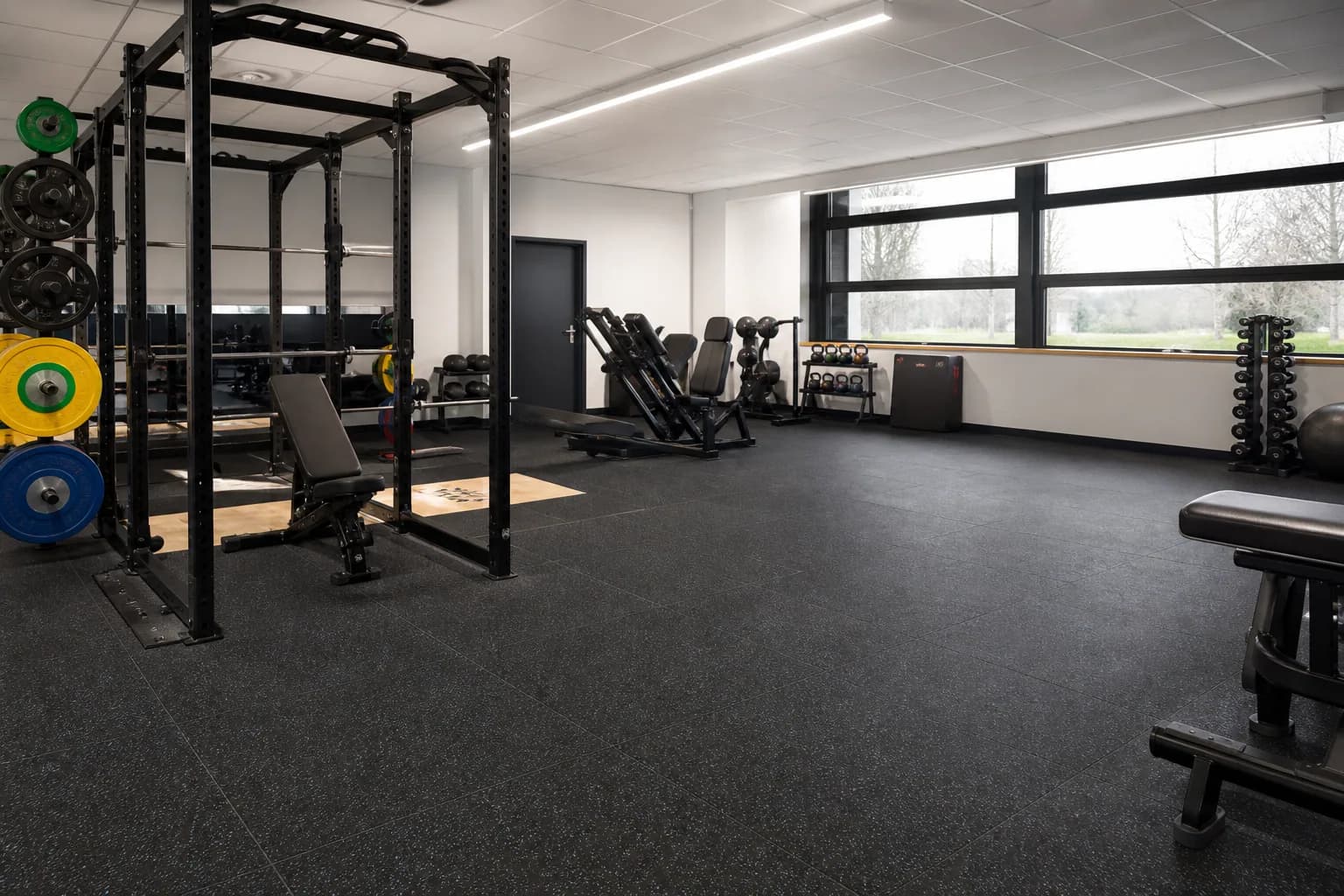 Secondary-school fitness and physical education room: primary training zone and equipment interface using durable rubber tile and roll system with supervised activity zones