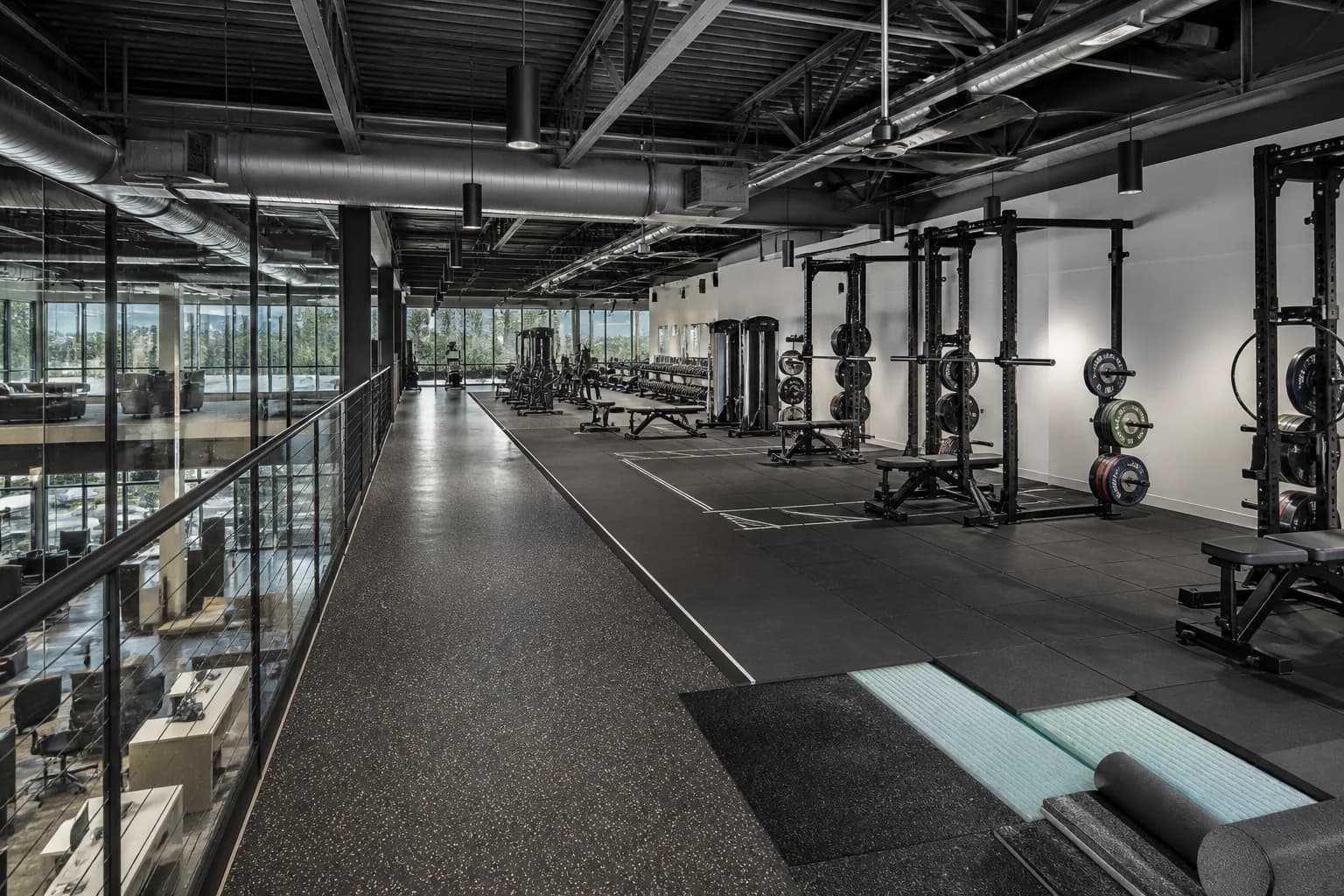 Upper-floor corporate gym above offices: overall floor zoning and circulation using source-zoned rubber surfaces and resilient underlay assemblies